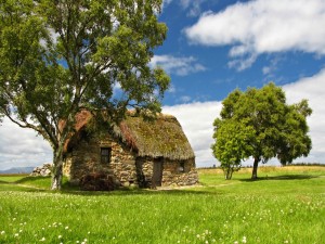 Cabaña de piedra en un prado verde