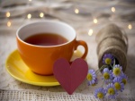 Corazón y flores junto a una taza de té