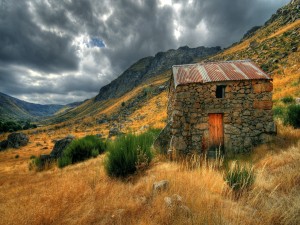 Postal: Pequeña cabaña de piedra en las montañas