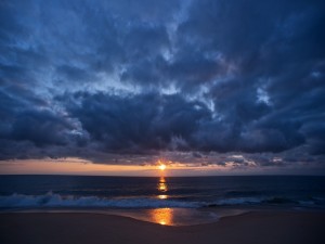 Postal: Amanecer nuboso sobre una playa