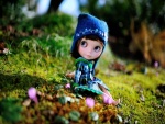 Muñeca sentada sobre la hierba