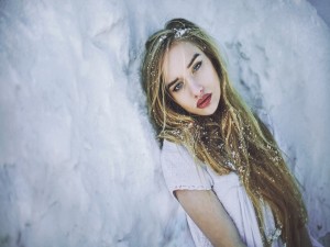 Postal: Chica tumbada sobre la fría nieve