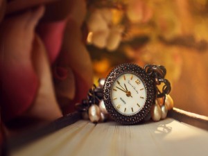 Reloj en una pulsera junto a unas perlas