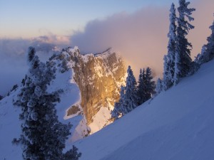 Sol iluminando una montaña nevada