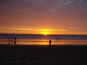 Postal: Sol en el horizonte de una hermosa playa