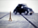 Pequeña torre Eiffel y un coche sobre un suelo de madera