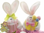 Tiernos conejitos con huevos de Pascua y flores