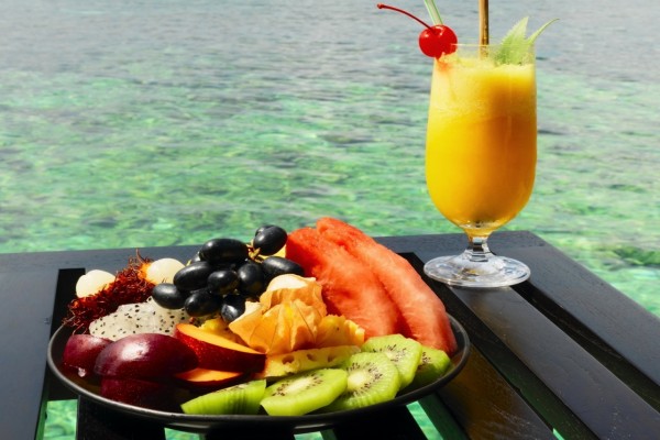 Zumo y frutas para degustar frente al mar