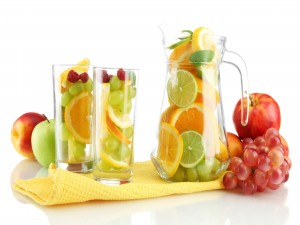 Vasos y jarra llenos de frutas frescas