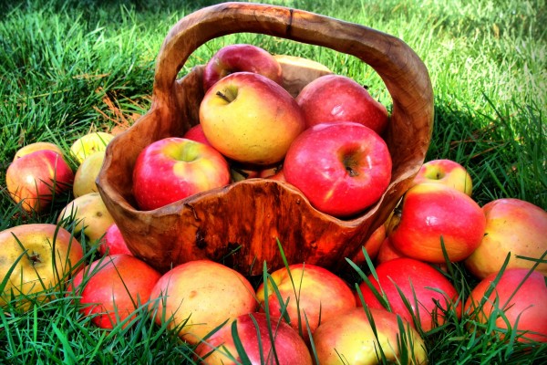 Manzanas junto a una bonita cesta de madera