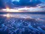 Amanecer reflejado en la orilla de una playa