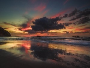 Hermoso cielo al amanecer reflejado en la orilla de una playa