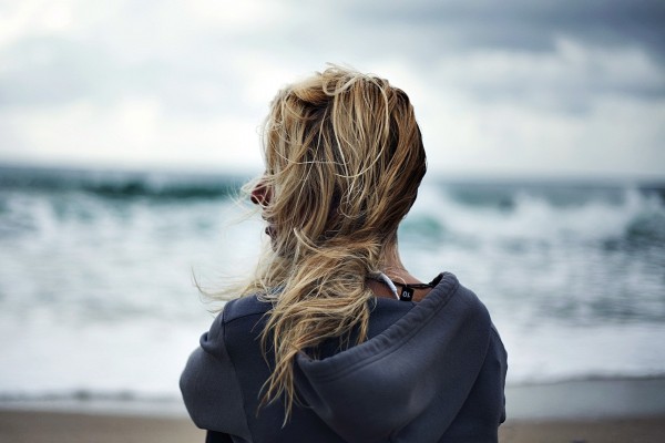Mujer contemplando el mar en un día de viento