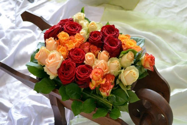 Bonito conjunto de rosas de colores en una carreta