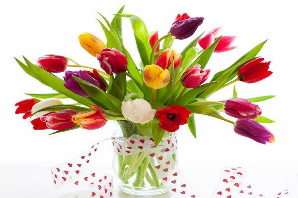 Bellos tulipanes en un recipiente de vidrio