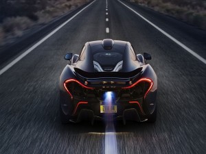 Un McLaren negro circulando por una carretera