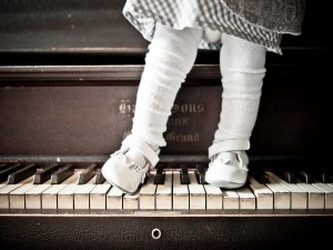 Una bebé sobre las teclas de un piano