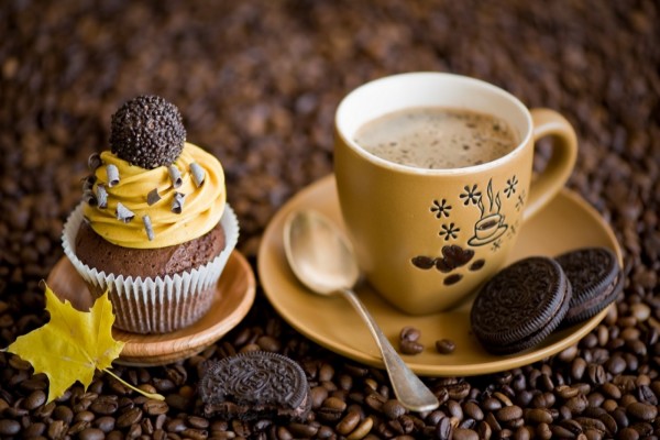 Café acompañado de un cupcake y unas galletas oreo