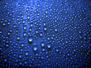 Gotas de agua en una superficie azul