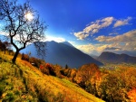 Sol iluminando las montañas y el valle en otoño