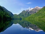 Cielo y montañas reflejadas en un tranquilo lago