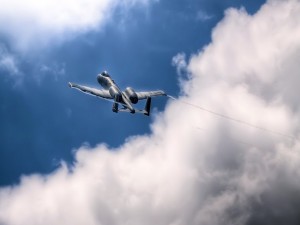 Postal: Avión militar volando junto a las nubes