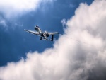 Avión militar volando junto a las nubes