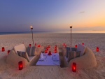 Romántica cena con velas en la arena de una playa
