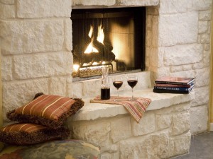 Dos copas de vino junto a una ardiente chimenea