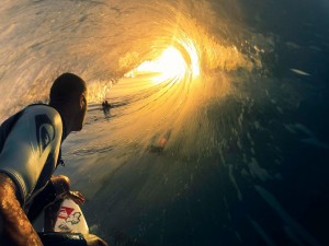 Surfista tomando una ola iluminada por el sol