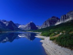 Lago y montañas bajo un deslumbrante cielo azul