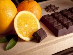 Jugosas naranjas y mandarina junto a una barra de chocolate
