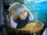 Bebé travieso volcando una fuente de espaguetis