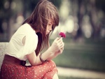 Chica contemplando una flor
