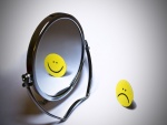 Emoticono reflejado en un espejo
