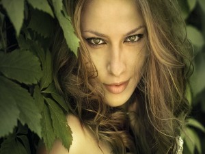 Mujer de ojos verdes entre unas hojas