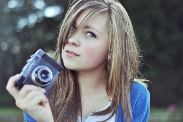 Chica guapa con una cámara de fotos
