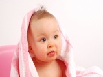 Bebé con una toalla rosa en la cabeza