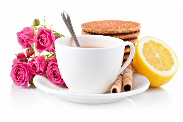 Rosas y galletas junto a una taza de té