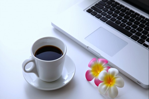 Taza de café junto a un ordenador