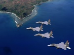 Formación de F-15 Eagle sobrevolando una isla volcánica