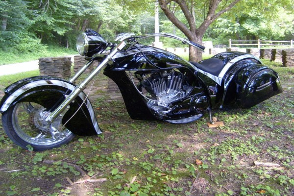 Una gran moto negra en un jardín