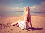 Chica sentada en una playa observando el mar