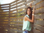 Chica junto a un vallado de madera