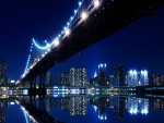 Puente y edificios iluminados en la noche