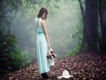 Chica paseando por el bosque con una cesta de flores