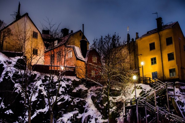 Farolas iluminando la nieve en una zona residencial