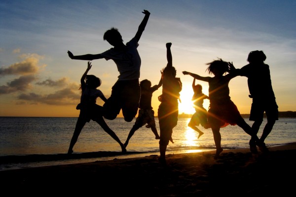 Grupo de amigos disfrutando en una playa al amanecer
