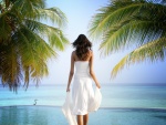 Mujer con un vestido blanco contemplando el mar