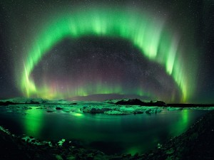 Una hermosa aurora boreal reflejada en el agua helada